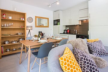 A kitchen with a table and chairs and a clock on the wall