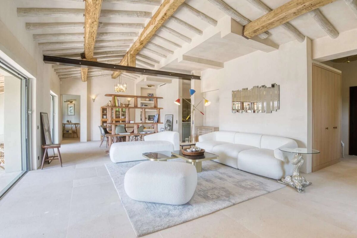 A living room with a white couch and chairs