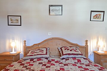 A bedroom with a wooden headboard and two lamps
