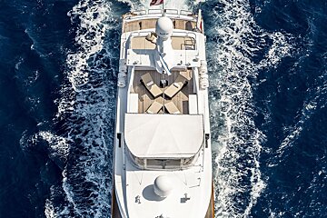 An aerial view of a large white yacht floating in the ocean