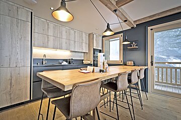 A kitchen with a large wooden table and chairs