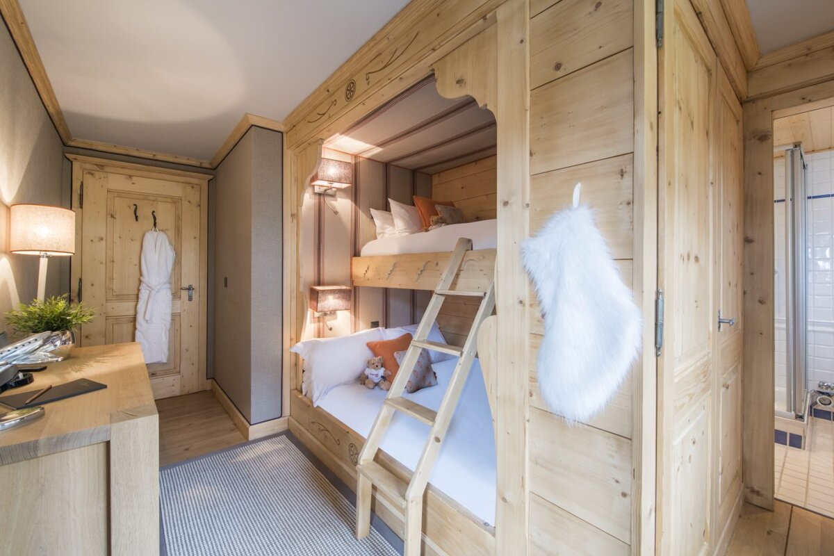 A bunk bed with a ladder in a wooden room