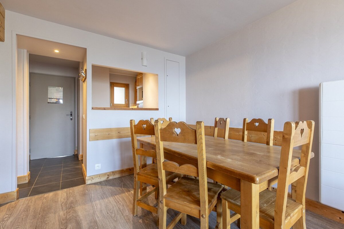 A dining room with a wooden table and chairs