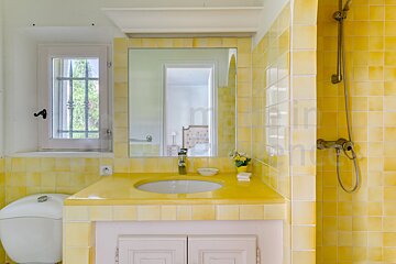 A bathroom with yellow tiles and a sink