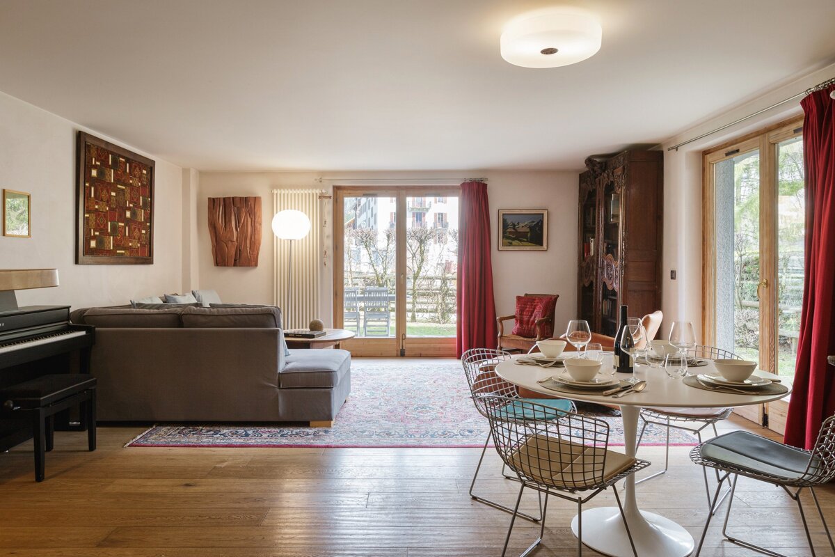 A living room with a table and chairs and a piano