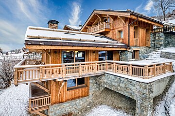 A large wooden house with trees carved into the railing