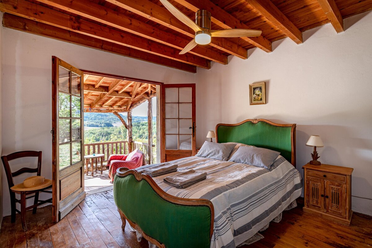 A bedroom with a green bed and a ceiling fan