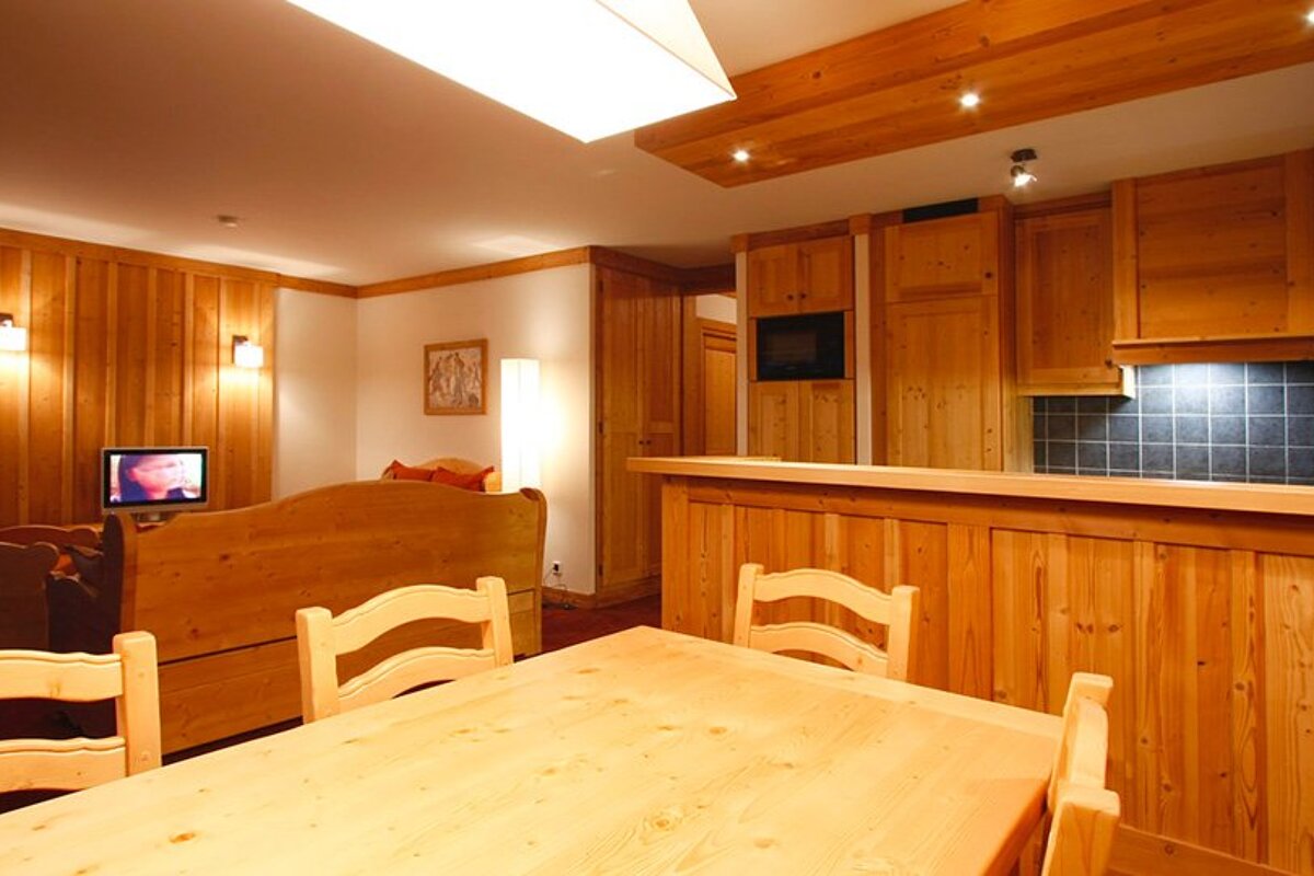 A living room with wood paneling and a table and chairs