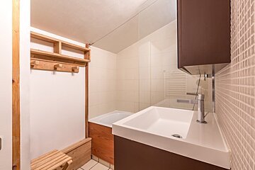 A bathroom with a sink and a wooden bench
