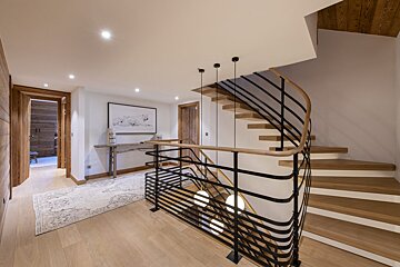A staircase with a metal railing and wooden steps