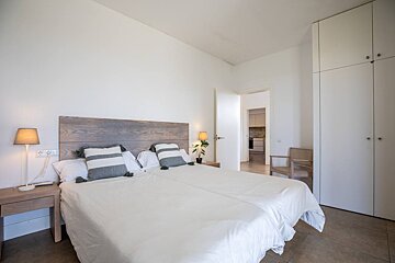 A bedroom with two beds and a lamp on the nightstand