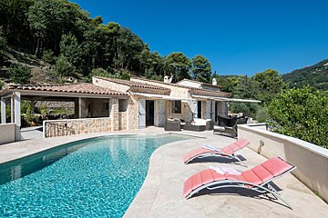 A house with a large swimming pool in front of it