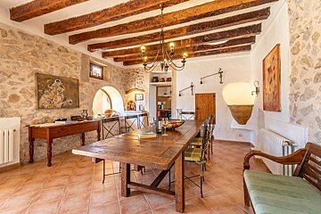 A dining room with a wooden table and chairs