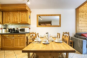 A kitchen with a table and chairs and a microwave