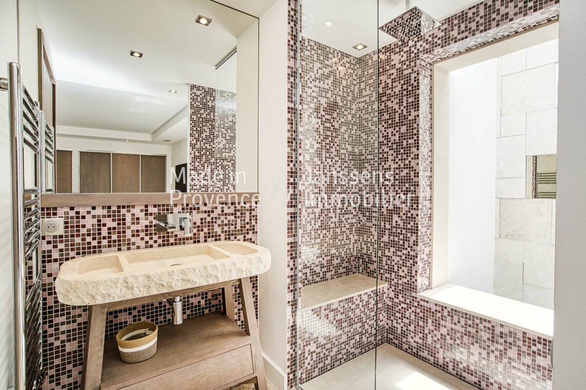 A bathroom with a sink and a shower with the words maison provence written on the wall
