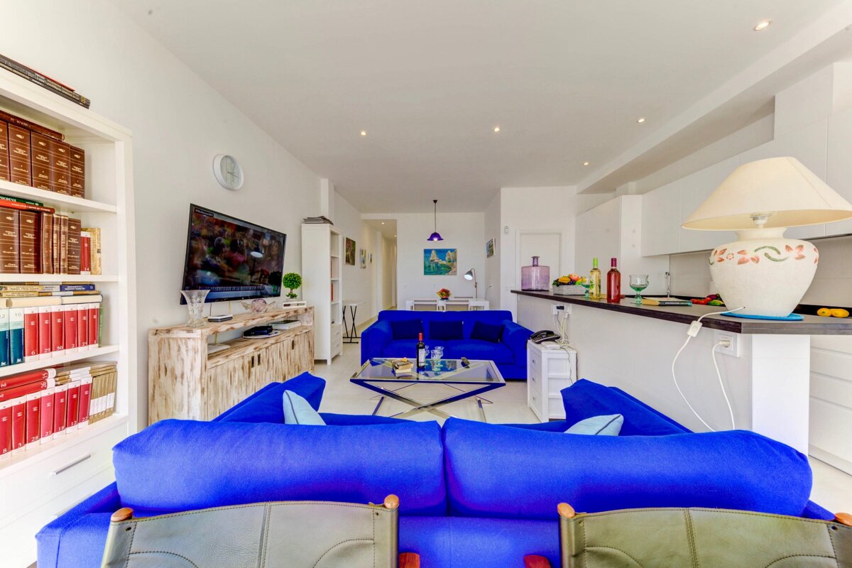 A living room with a blue couch and a flat screen tv