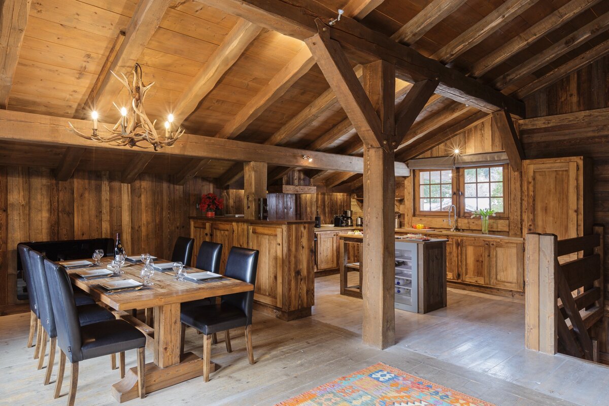 A dining room with a table and chairs and a chandelier