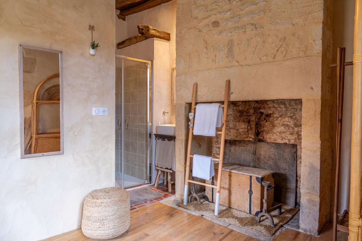 A bathroom with a fireplace and a ladder with towels on it