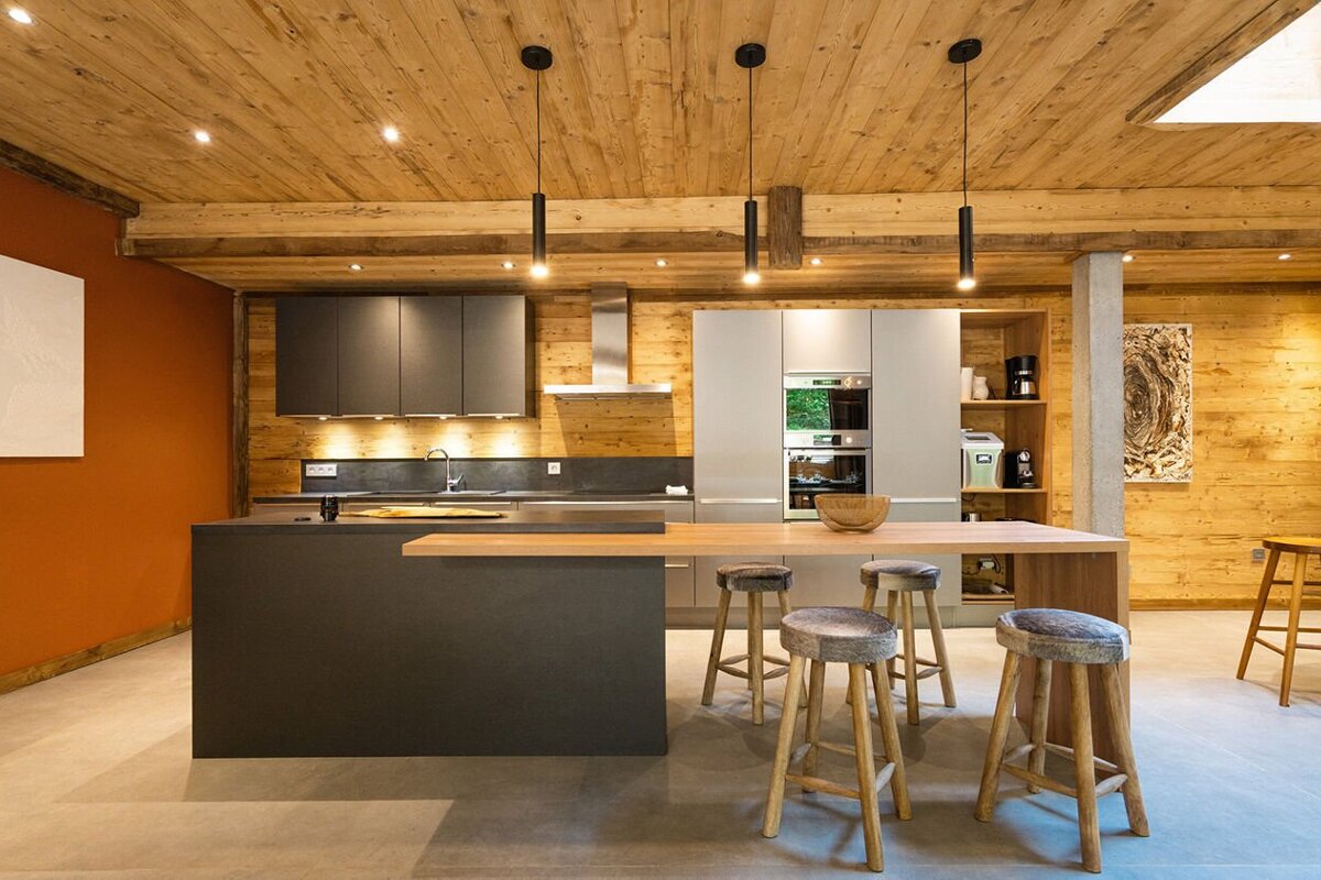 A kitchen with a wooden ceiling and stools
