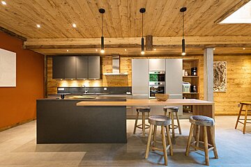 A kitchen with a wooden ceiling and stools