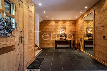 A hallway with a mirror and a sign that says tenso