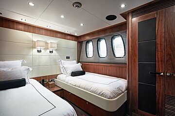 A small bedroom with two beds and a window
