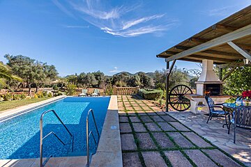 A large swimming pool with a wagon wheel in the background