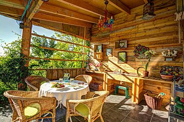 A wooden room with wicker chairs and a table