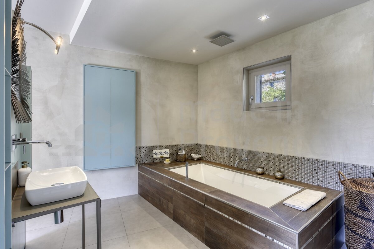 A bathroom with a large bathtub and a sink
