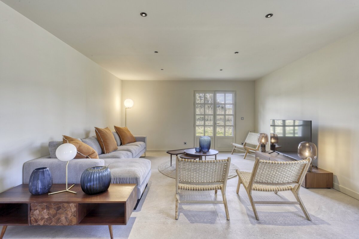 A living room with a couch and chairs and a television
