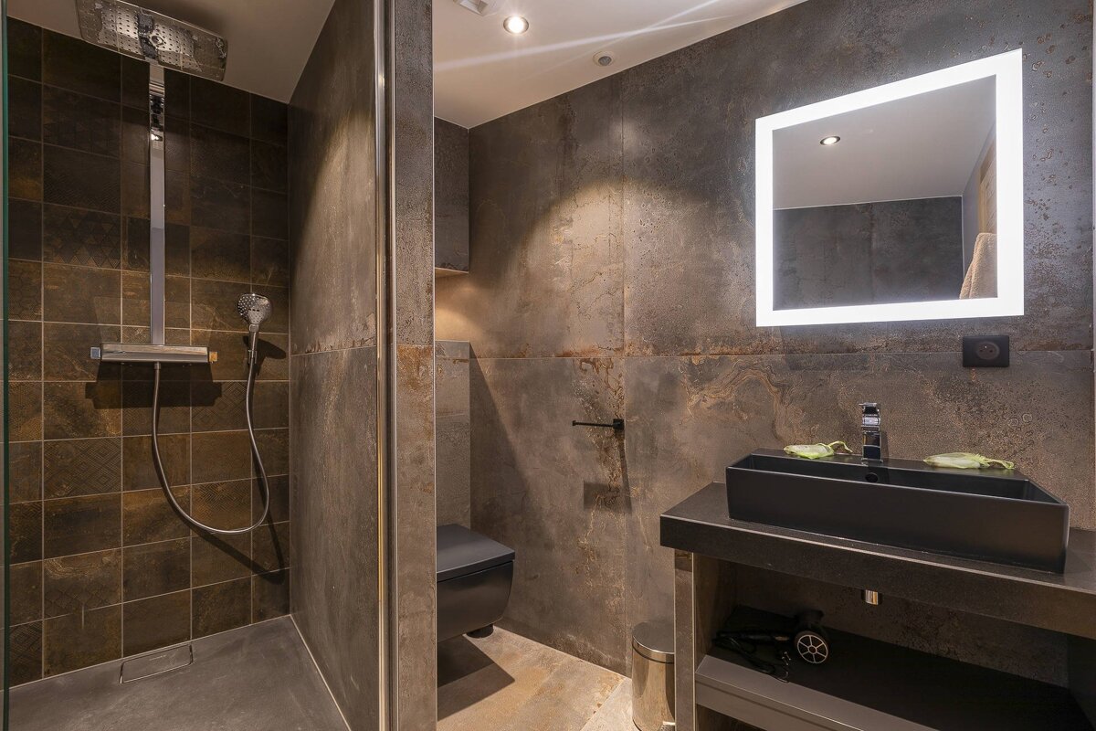 A bathroom with a black sink and a mirror