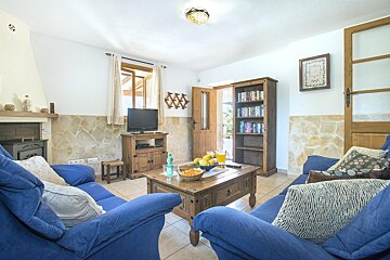 A living room with blue furniture and a clock on the wall
