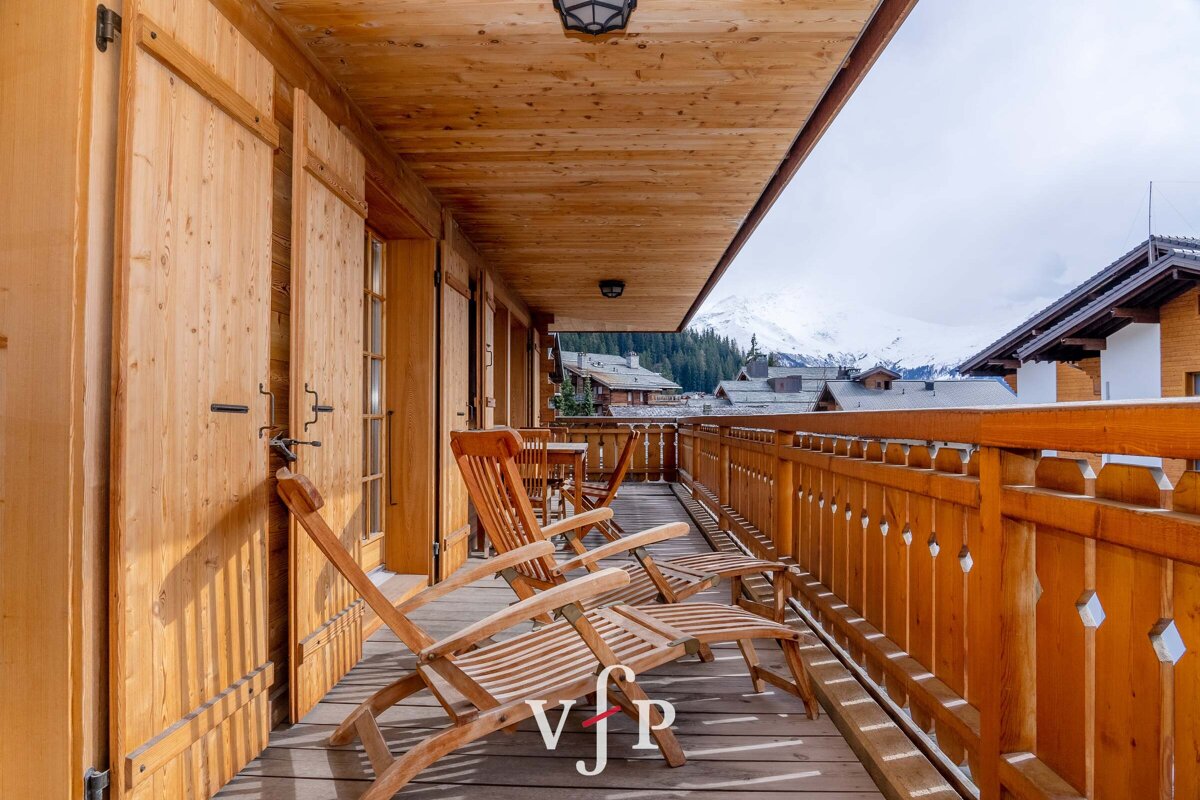 A wooden balcony with chairs and ottomans and a sign that says vip