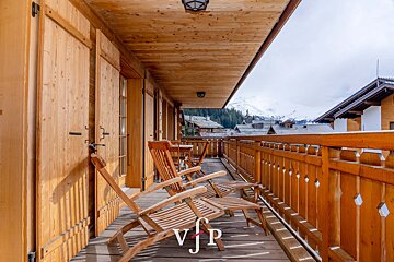 A wooden balcony with chairs and ottomans and a sign that says vip