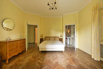 A bedroom with yellow walls and a wooden floor