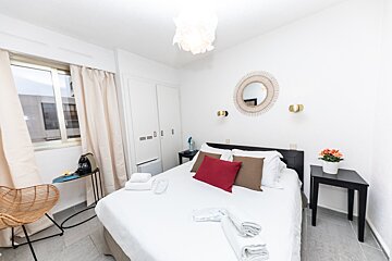 A bedroom with a bed and a mirror on the wall