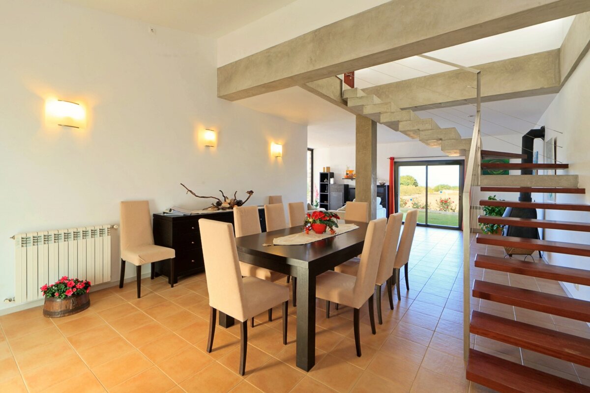 A dining room with a table and chairs and stairs
