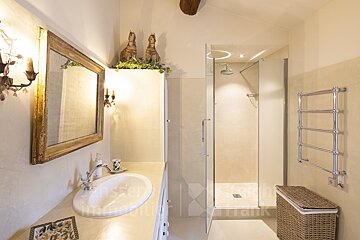 A bathroom with a sink and a walk in shower