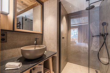 A bathroom with a sink and a walk in shower