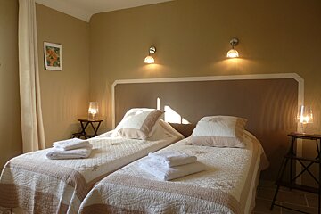 A bedroom with two beds and a picture on the wall