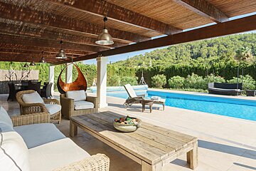 A patio area with wicker furniture and a swimming pool