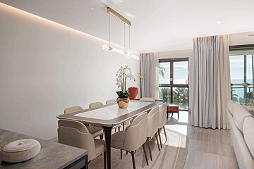 A dining room with a marble table and chairs