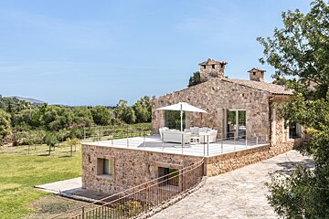 A stone house with a white umbrella in front of it