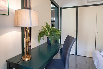 A desk with a lamp and a plant on it