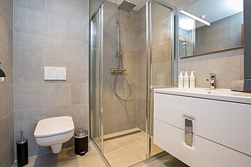 A bathroom with a toilet a sink and a shower