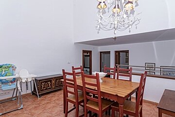 A dining room with a table and chairs and a high chair
