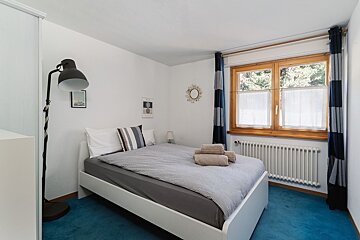 A bedroom with a bed a lamp and a window