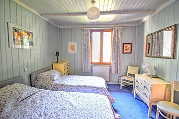 A bedroom with two beds a dresser and a mirror
