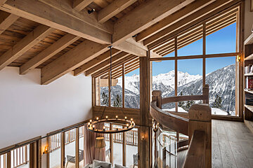A wooden house with a spiral staircase and a view of the mountains