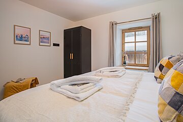 A bedroom with a large bed and a window